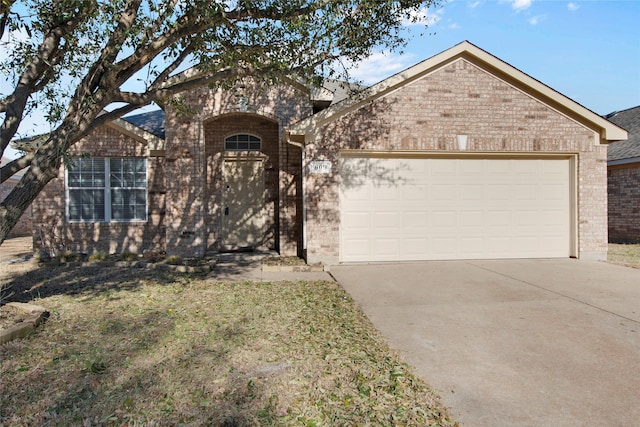 view of front of property with brick siding, concrete driveway, and a garage