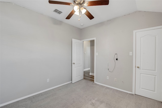 unfurnished bedroom featuring visible vents, baseboards, lofted ceiling, and carpet floors