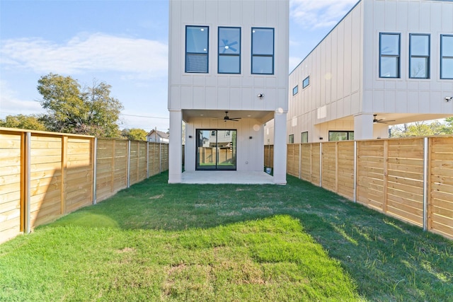 back of property featuring ceiling fan, board and batten siding, and a fenced backyard