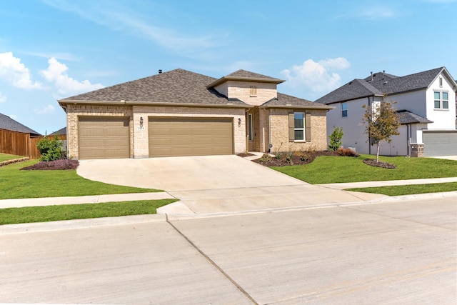 view of front of house with driveway, brick siding, a garage, and a front yard