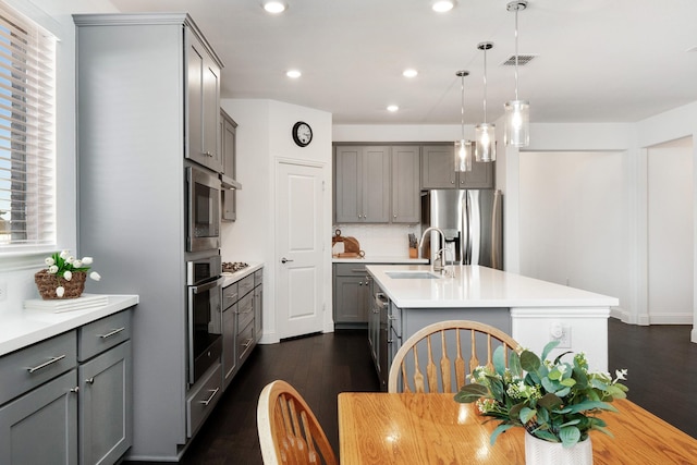 1624 Thunderbird Dr, Fort Worth, TX 76052 - kitchen featuring appliances with stainless steel finishes, gray cabinetry, a sink, and a center island with sink
