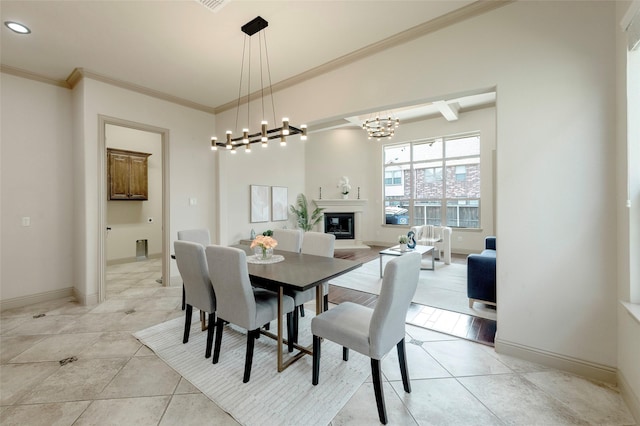 dining area featuring light tile patterned floors, ornamental molding, a glass covered fireplace, and baseboards