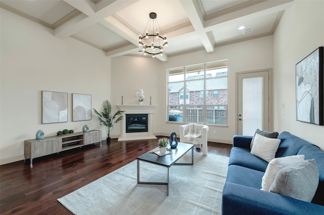 living area with beam ceiling, a glass covered fireplace, wood finished floors, coffered ceiling, and baseboards