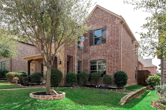 traditional-style home with brick siding and a front lawn