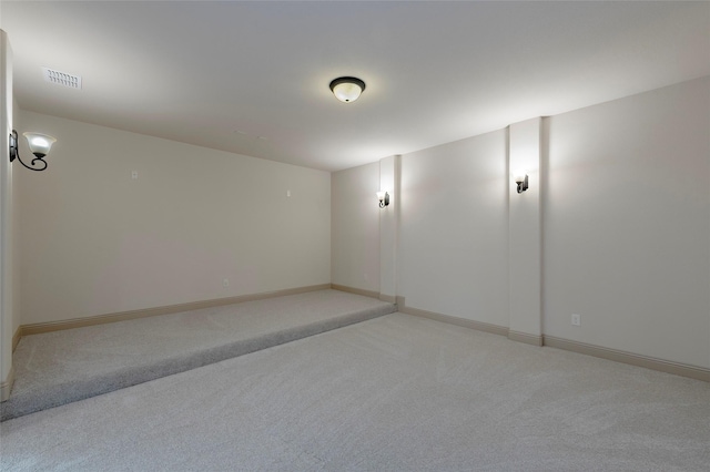 spare room with baseboards, visible vents, and light colored carpet