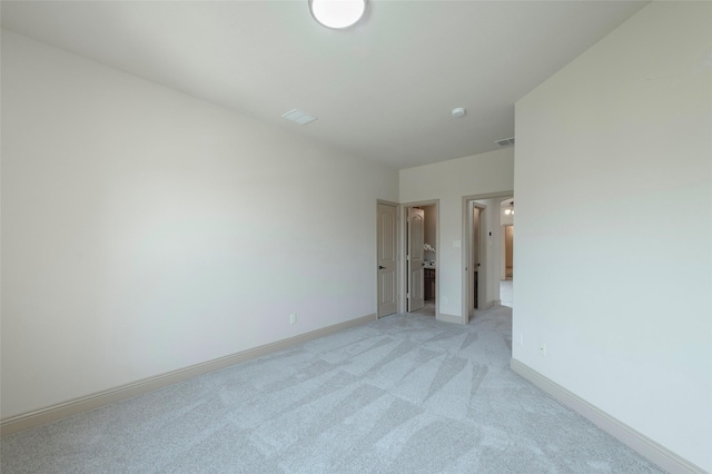 unfurnished bedroom featuring light carpet, visible vents, and baseboards