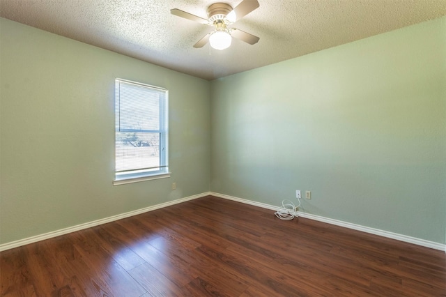 empty room with dark wood-type flooring, a textured ceiling, baseboards, and a ceiling fan