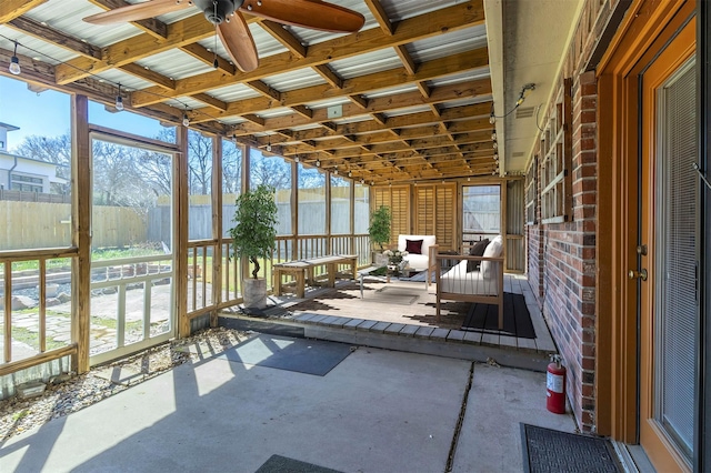 unfurnished sunroom featuring ceiling fan