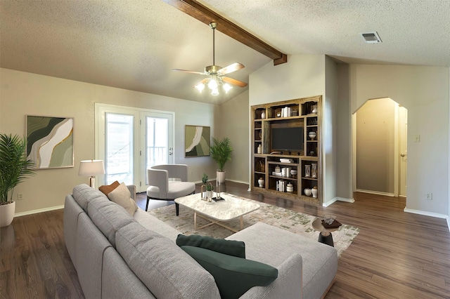 living area featuring visible vents, arched walkways, wood finished floors, vaulted ceiling with beams, and a textured ceiling