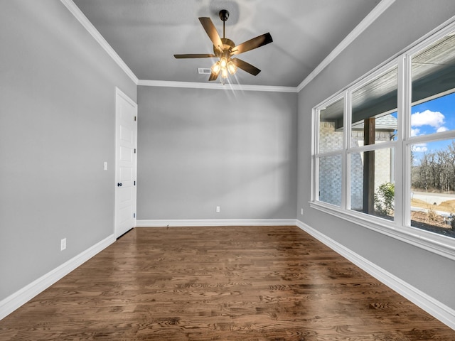 spare room with ornamental molding, dark wood finished floors, and baseboards