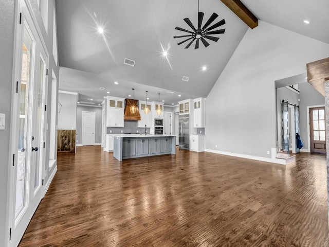 unfurnished living room featuring high vaulted ceiling, visible vents, a ceiling fan, beam ceiling, and dark wood finished floors