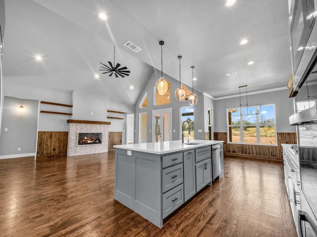 kitchen featuring visible vents, a tile fireplace, a wainscoted wall, gray cabinetry, and a sink