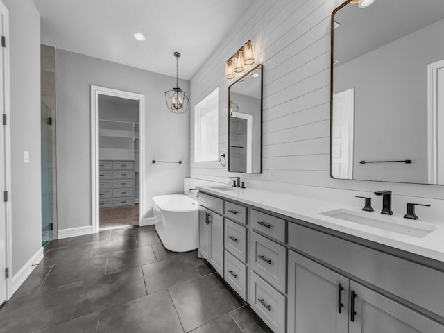 bathroom with a freestanding tub, tile patterned flooring, a sink, double vanity, and a stall shower