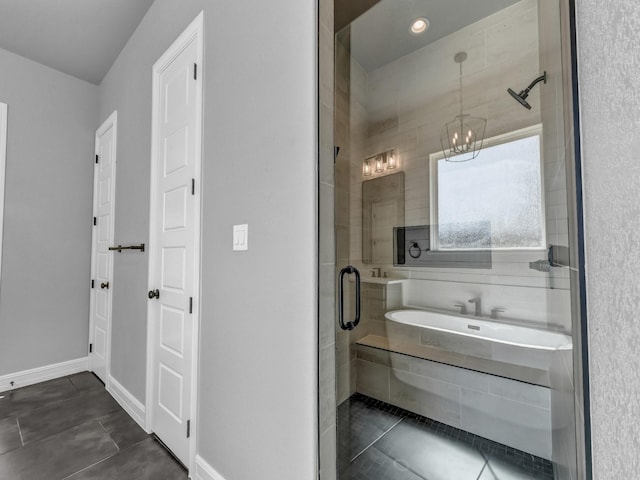 bathroom with a stall shower, a notable chandelier, baseboards, and tile patterned floors