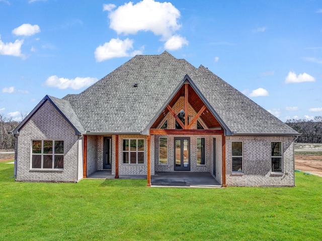 rear view of house with a patio area, french doors, roof with shingles, and a lawn