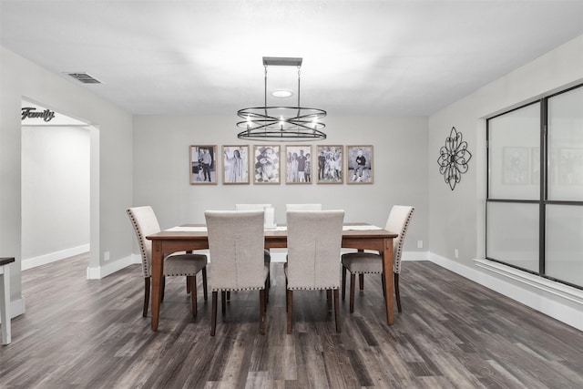 dining room featuring baseboards, visible vents, dark wood finished floors, and a notable chandelier