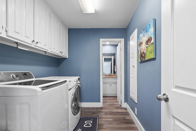 laundry area featuring cabinet space, dark wood-type flooring, a sink, washer and dryer, and baseboards