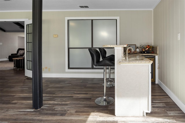 interior space featuring baseboards, visible vents, dark wood-type flooring, and crown molding