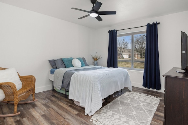 bedroom featuring a ceiling fan, baseboards, and wood finished floors