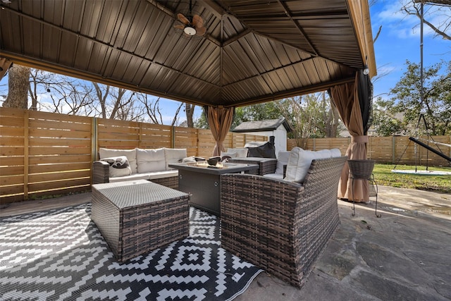 view of patio / terrace featuring a fenced backyard, an outbuilding, an outdoor hangout area, and a gazebo