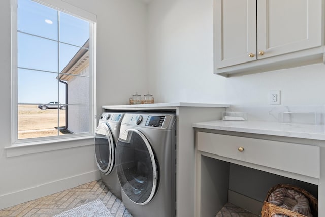 washroom featuring washer and clothes dryer, brick floor, cabinet space, and baseboards