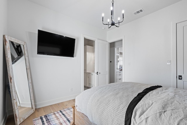 bedroom with light wood-style floors, visible vents, baseboards, and an inviting chandelier