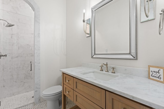 bathroom with vanity, a shower stall, and toilet