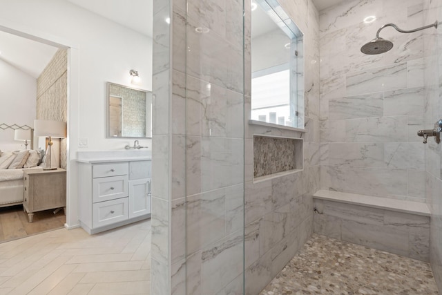 ensuite bathroom featuring a marble finish shower, connected bathroom, and vanity