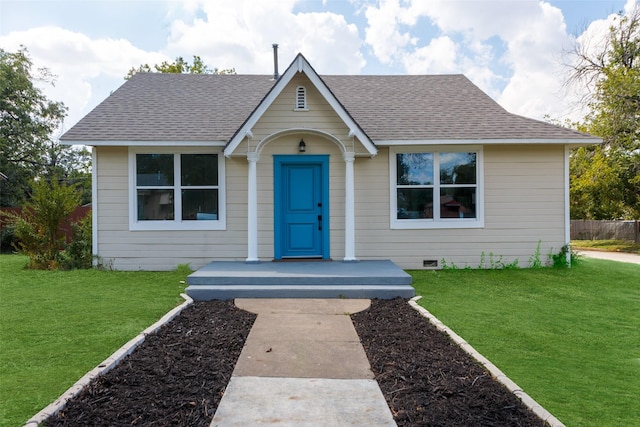 bungalow-style house featuring roof with shingles, a front lawn, and crawl space