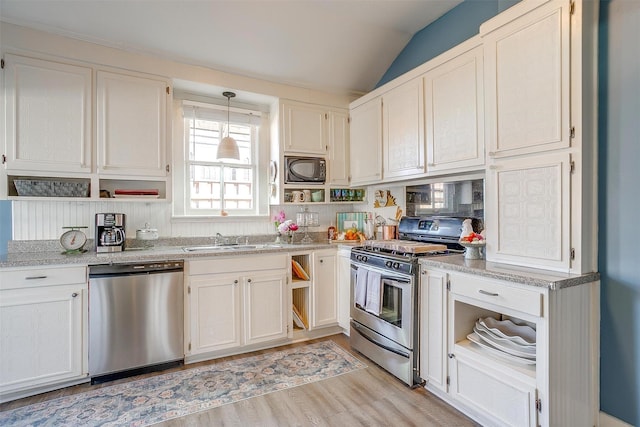 kitchen with open shelves, appliances with stainless steel finishes, and a sink