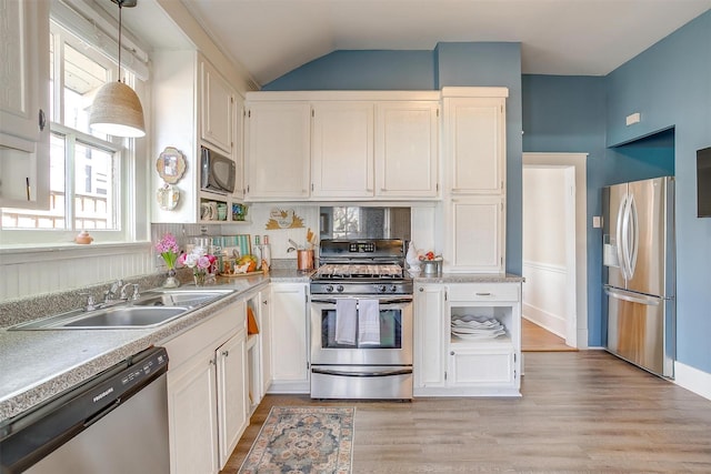 kitchen featuring stainless steel appliances, light countertops, white cabinets, and a sink