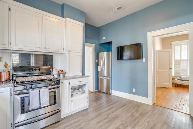 kitchen with light wood finished floors, white cabinetry, visible vents, and stainless steel appliances