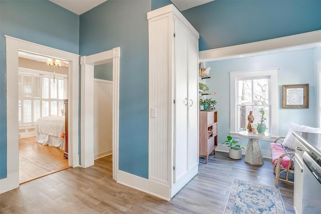 interior space featuring a healthy amount of sunlight, an inviting chandelier, and wood finished floors