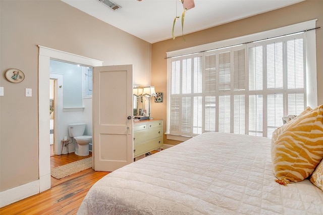 bedroom featuring multiple windows, wood finished floors, and visible vents