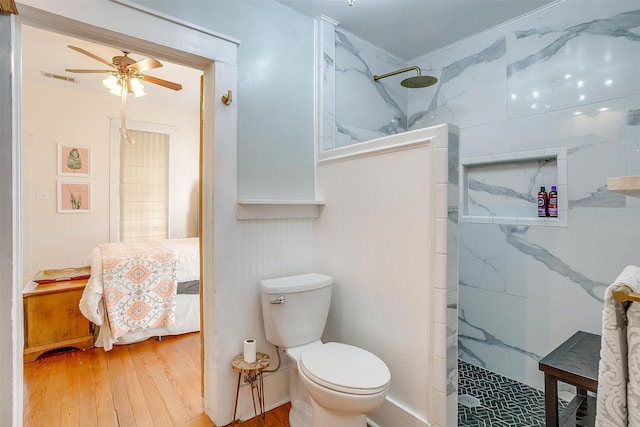 full bath featuring visible vents, toilet, ceiling fan, wood finished floors, and walk in shower