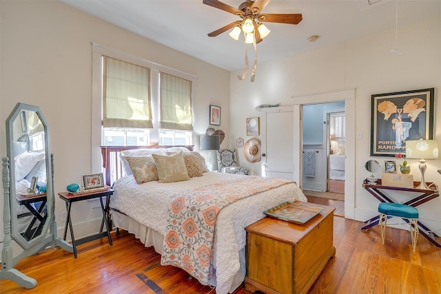 bedroom with ceiling fan, light wood-style flooring, attic access, and baseboards