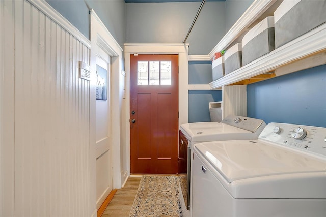 clothes washing area featuring light wood-style floors and independent washer and dryer