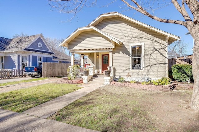 bungalow-style home with a porch, a front yard, and fence