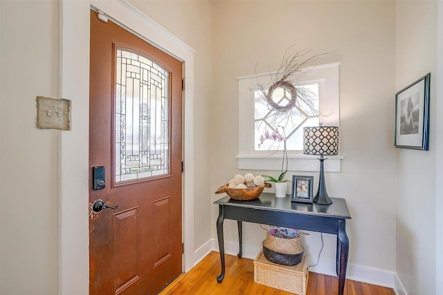 foyer featuring baseboards and wood finished floors