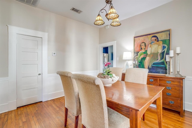 dining area with a notable chandelier, baseboards, visible vents, and light wood-style floors