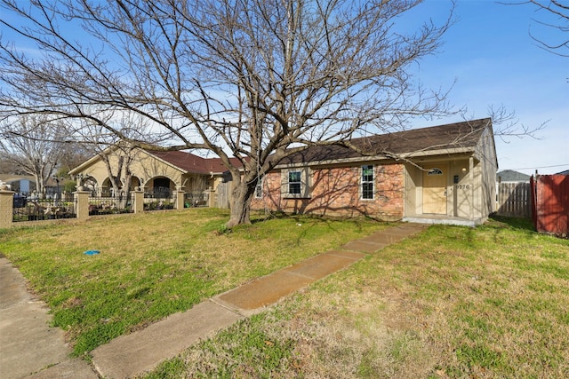 view of front of property with a front lawn, fence private yard, and brick siding