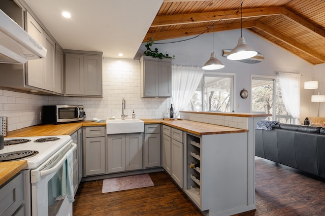 kitchen featuring butcher block countertops, stainless steel microwave, gray cabinets, and a sink