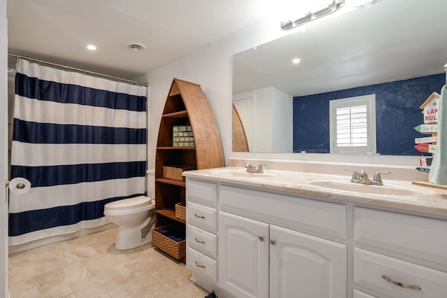 full bathroom featuring visible vents, double vanity, a sink, and toilet