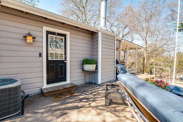 wooden terrace featuring area for grilling and cooling unit