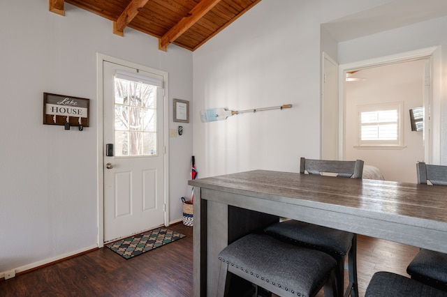 entryway with a wealth of natural light, dark wood-style flooring, wooden ceiling, and lofted ceiling with beams