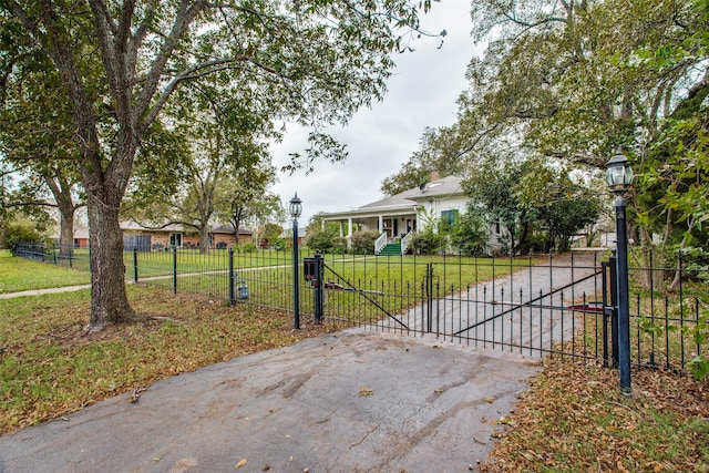 view of gate with a fenced front yard and a yard