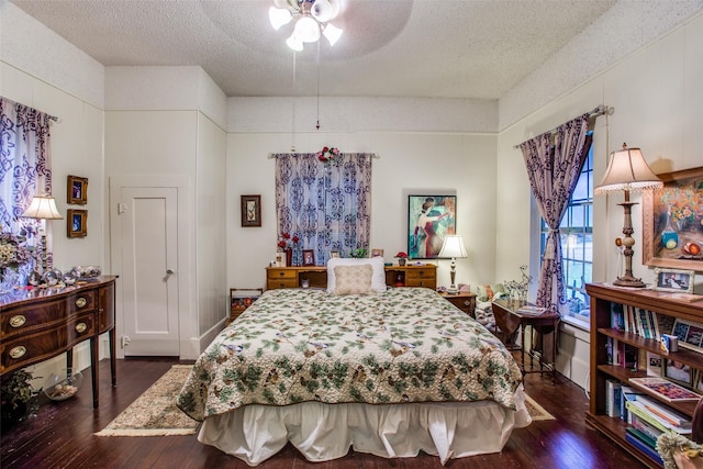 bedroom featuring wood-type flooring, ceiling fan, and a textured ceiling