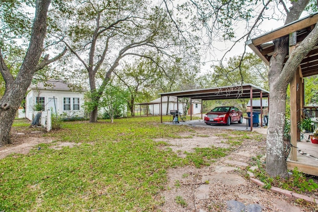 view of yard featuring dirt driveway and a detached carport