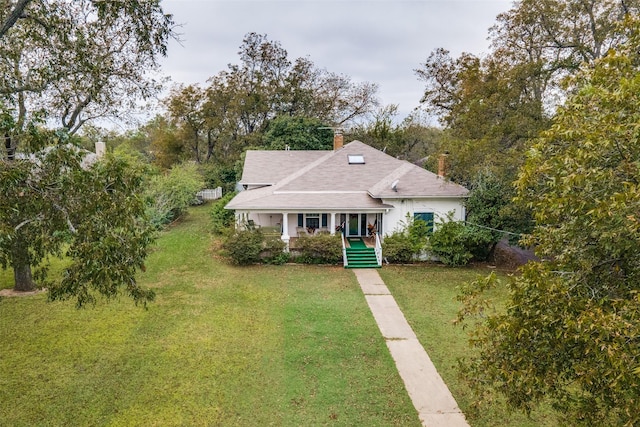 bungalow-style home with a porch, a chimney, and a front yard