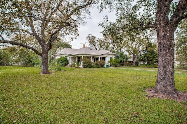 view of front facade featuring a chimney and a front yard